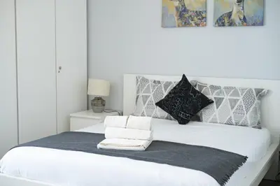 a white bedroom with two beds with pink blankets at Palmeiras do Golfe - 3 bed. apartment - Vilamoura in Vilamoura