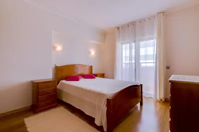 a bedroom with a bed and a large window at Paraísos do Pinhal - 2 Bedrooms - Vilamoura in Vilamoura