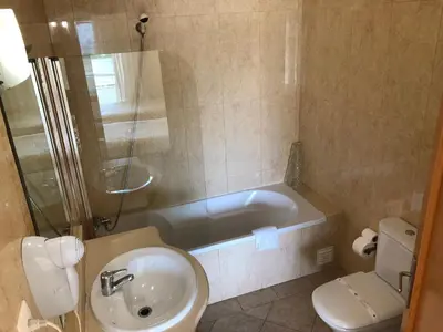 a bathroom with a tub and a sink and a toilet at Apartamentos Pomba Branca in Olhos de Água
