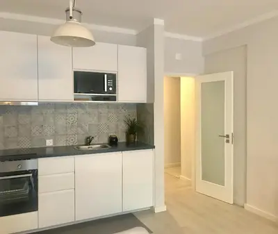 a white kitchen with a sink and a microwave at Paz na Areia in Quarteira