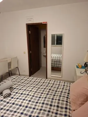 a bedroom with a bed with a checkeredkered blanket at Eucalipto in Faro