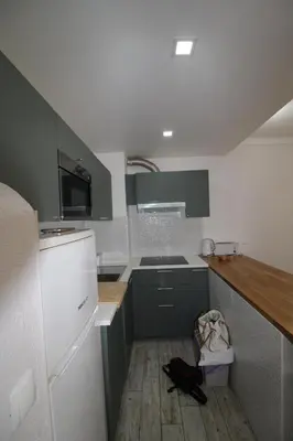 a kitchen with green cabinets and a white refrigerator at Apartamento T0 Albufeira perto do Centro in Albufeira