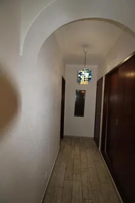 an empty hallway with a door and a chandelier at Apartamento T0 Albufeira perto do Centro in Albufeira