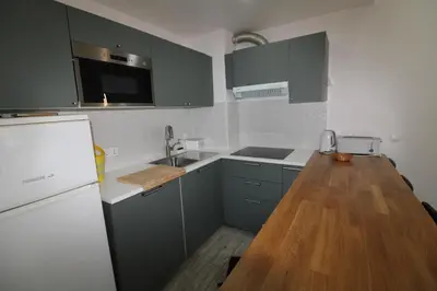 a kitchen with blue cabinets and a wooden counter top at Apartamento T0 Albufeira perto do Centro in Albufeira