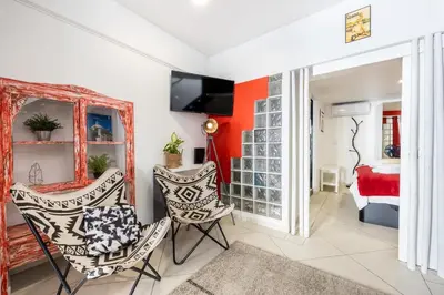 a living room with a red accent wall and two chairs at Townhouse N7 - Albufeira in Albufeira