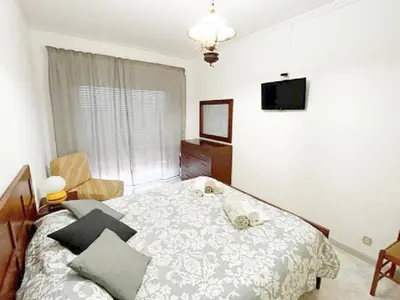 a bedroom with a bed and a tv on the wall at Quarteira Beach Holidays in Quarteira
