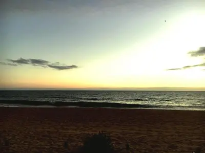 a sunset on a beach with the ocean at Quarteira Beach Holidays in Quarteira