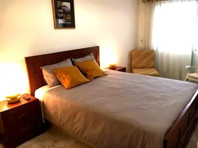 a bedroom with a large bed and a chair at Quarteira Beach Holidays in Quarteira