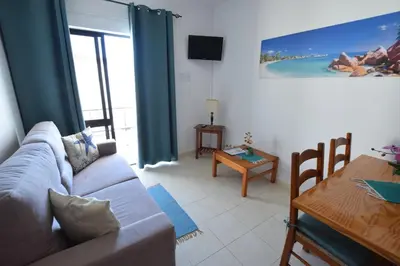 a living room with a couch and a table at Apartamentos Carruna in Albufeira