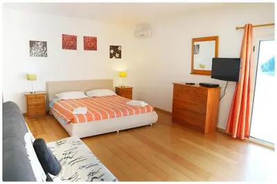 a bedroom with a bed and a dresser and a television at Casa do Mar by Laranjal Rentals in Albufeira