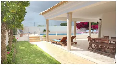 a pavilion with a table and chairs on a patio at Casa do Mar by Laranjal Rentals in Albufeira