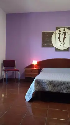 a bedroom with a bed and a table and a lamp at Vila Olímpica in Albufeira