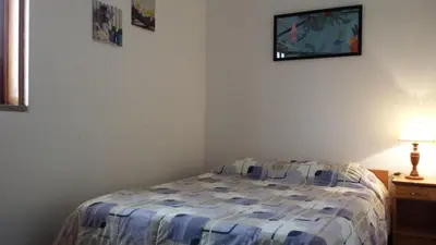 a bedroom with a bed and a tv on the wall at Vila Olímpica in Albufeira