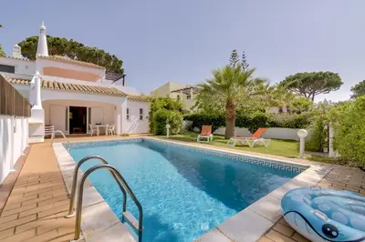 a villa with a swimming pool and a house at Vila Caracas - V3 - Vilamoura in Vilamoura