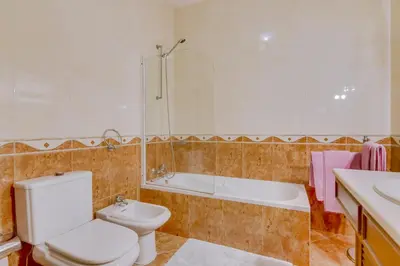 a bathroom with a toilet and a tub and a sink at Vila Caracas - V3 - Vilamoura in Vilamoura