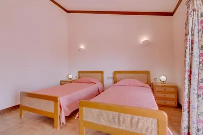 two twin beds in a room with white walls at Vila Caracas - V3 - Vilamoura in Vilamoura