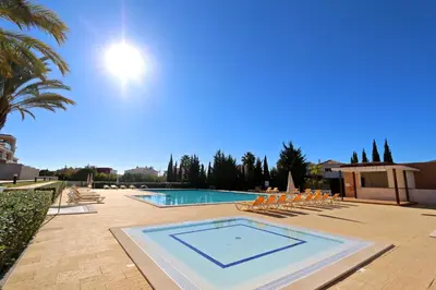 a swimming pool with a bunch of chairs and a palm tree at Villa Dolce Vita CD 81 - Clever Details in Vilamoura