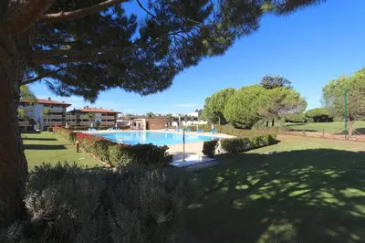 a swimming pool in a park with a tree at Villa Dolce Vita CD 81 - Clever Details in Vilamoura