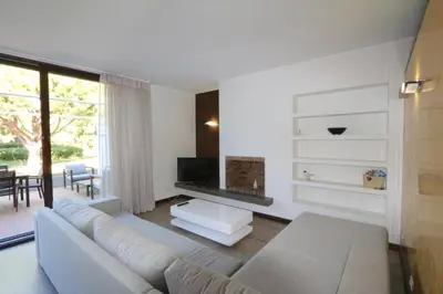 a living room with a white couch and a television at Villa Dolce Vita CD 81 - Clever Details in Vilamoura