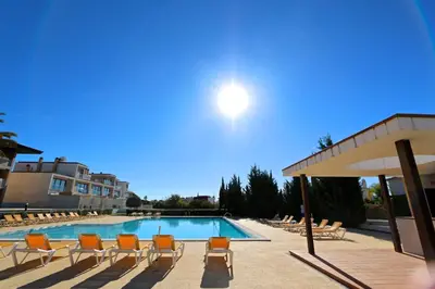 a swimming pool with lounge chairs and an umbrella at Villa Dolce Vita CD 81 - Clever Details in Vilamoura