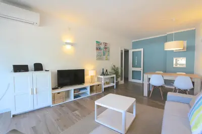 a living room with a couch and a tv and a table at Ténis Golf Mar CD 14 - Clever Details in Vilamoura