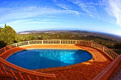 a swimming pool with a wooden rail around it at Elegant family house in Loulé with private pool in Loulé