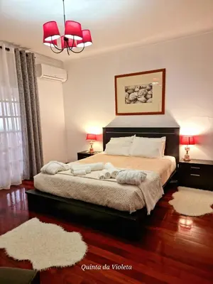 a bedroom with a bed with red lamps and a chandelier at Elegant family house in Loulé with private pool in Loulé