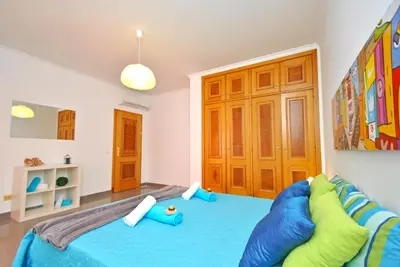a bedroom with a blue bed and a blue couch at Apartment Ipanema 3 by Algarve Vacation in Albufeira