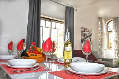 a dining room table with red plates and wine glasses at Apartment Ipanema 3 by Algarve Vacation in Albufeira