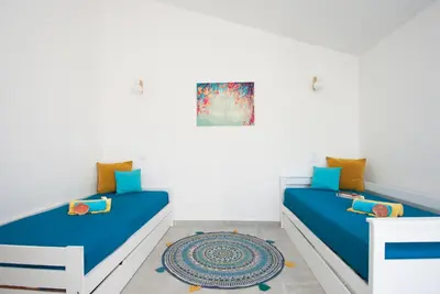 a bedroom with two beds and a rug at Villa São Paulo by Algarve Vacation in Albufeira