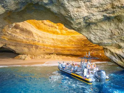a boat in the water in front of a cave at Villa São Paulo by Algarve Vacation in Albufeira
