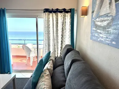 a living room with a couch and a view of the ocean at Mar apartment wonderful view - Quarteira in Quarteira
