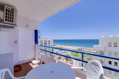 a balcony with a table and chairs and the ocean at Mar apartment wonderful view - Quarteira in Quarteira