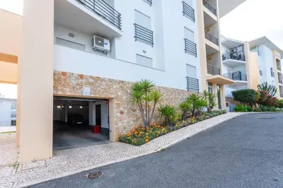a row of trees in a yard next to a building at BnB Homes Ocean view Apartment with 3 spacious Terraces, 2 Swimming pools & Tennis court in Albufeira