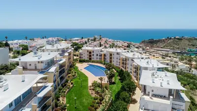 a staircase leading to a beach with rocks in the ocean at BnB Homes Ocean view Apartment with 3 spacious Terraces, 2 Swimming pools & Tennis court in Albufeira