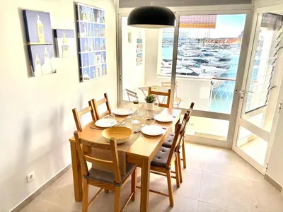 a dining room with a wooden table and chairs at The Marina Plaza Vilamoura in Vilamoura