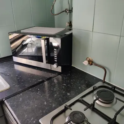 a kitchen counter with a microwave on top of a stove at Modern Top Floor Apartment 60m2 - Balcony with Pool & Sea View - Vilamoura in Vilamoura