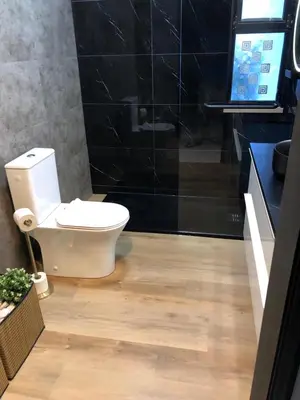 a bathroom with a toilet and a black wall at Modern Top Floor Apartment 60m2 - Balcony with Pool & Sea View - Vilamoura in Vilamoura
