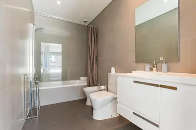a bathroom with a toilet and a sink and a shower at Cavalo Preto Luxury Beach Apartment by Golden Zenith in Quarteira