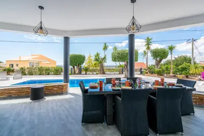 a dining room with a table and chairs and a pool at Casa Laranja Three bedroom Villa in Loulé