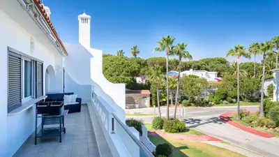 a balcony with a view of a street and palm trees at Sienna in Vale do Lobo