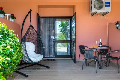 a patio with a swing and a table and chairs at Clementina Duplex apartment in Albufeira