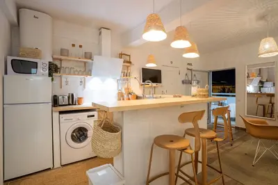 a kitchen with white appliances and a counter with stools at Baixa de Faro Rooftop in Faro