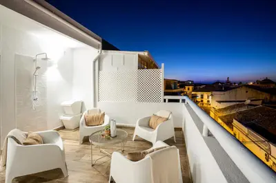 a balcony with white chairs and a table at Baixa de Faro Rooftop in Faro