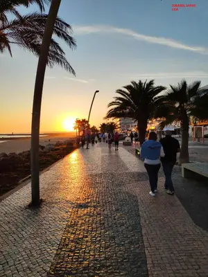a group of people walking down a sidewalk near the beach at Alsol C 5365-1 in Quarteira