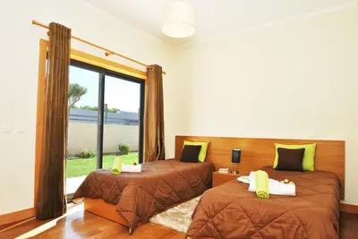 a bedroom with two beds and a large window at Villa Paraty by Algarve Vacation in Albufeira