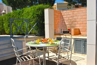 a table and chairs on a patio with food on it at Villa Paraty by Algarve Vacation in Albufeira