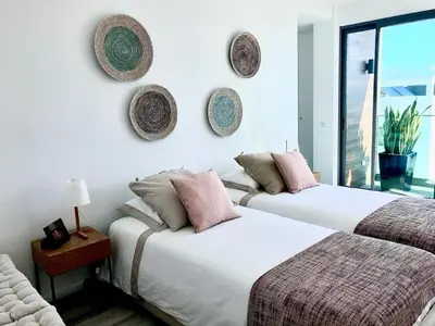 two beds in a room with plates on the wall at Vila Meluna in Albufeira