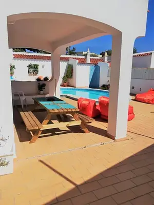 a patio with a picnic table and a pool at Luxurious villa in Albufeira with pool in Albufeira