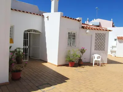 a courtyard of a white house with potted plants at Luxurious villa in Albufeira with pool in Albufeira